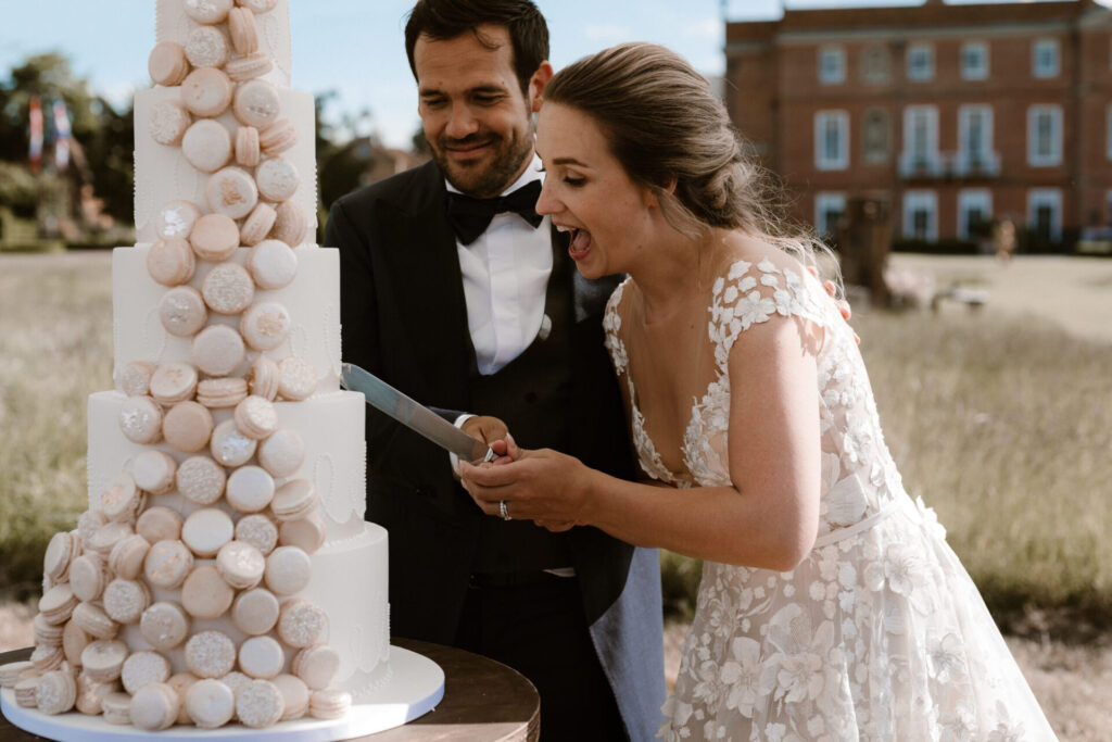 Couple cutting Unique wedding Cakes by Yevnig 'Macaron Chic' wedding cake at Four Seasons Hampshire  