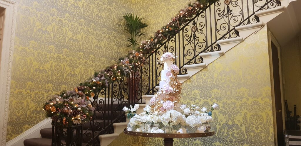 Luxury By Yevnig Christmas wedding cake by the Grand Staircase at Hedsor House