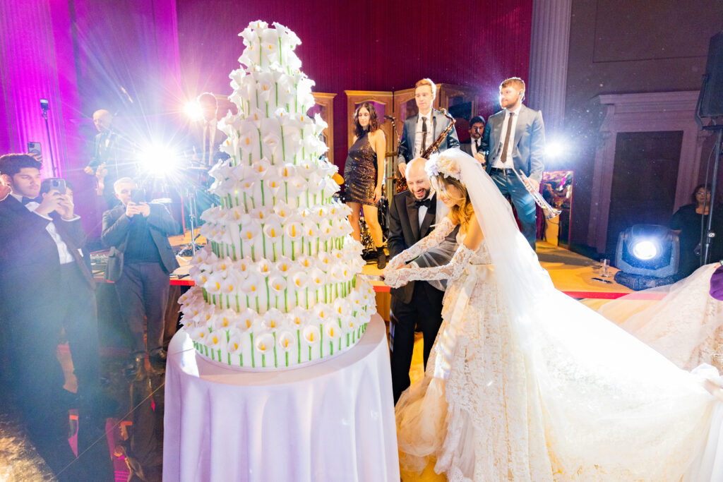 bride and groom cutting a large contemporary floral wedding cake from By Yevnig at The Banqueting House, Whitehall, London