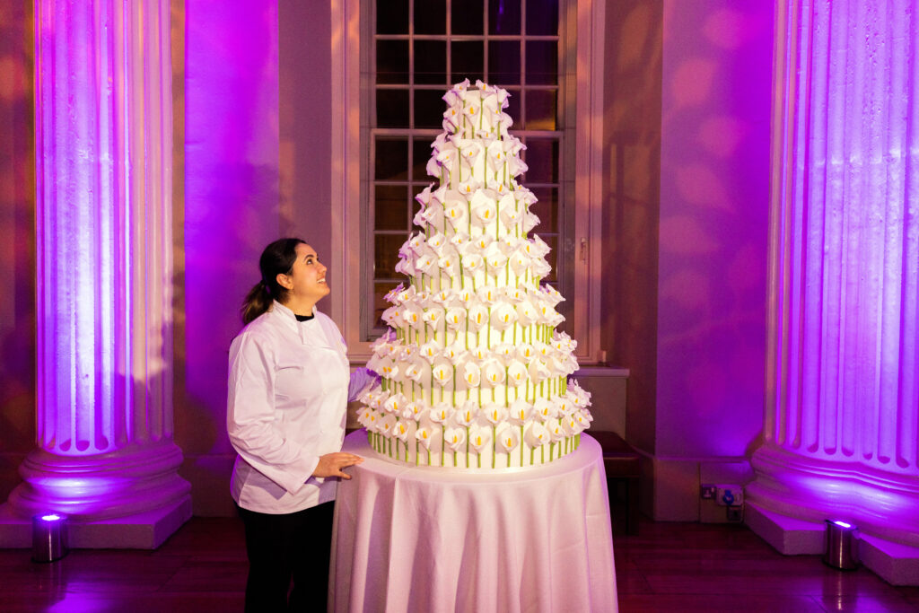 Yevnig Davis, creative director and master baker at By Yevnig gazes to the top of her magnificent contemporary wedding cake decorated with 500 calla lilies hand-crafted in sugar paste.