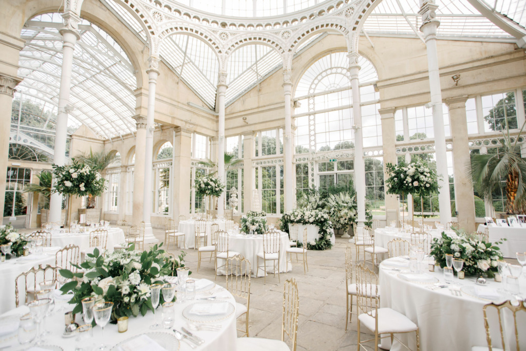 Inside the Great Conservatory at Syon Park, under the dome. The room has been set up for a beautiful wedding with green and white floral decorations.
