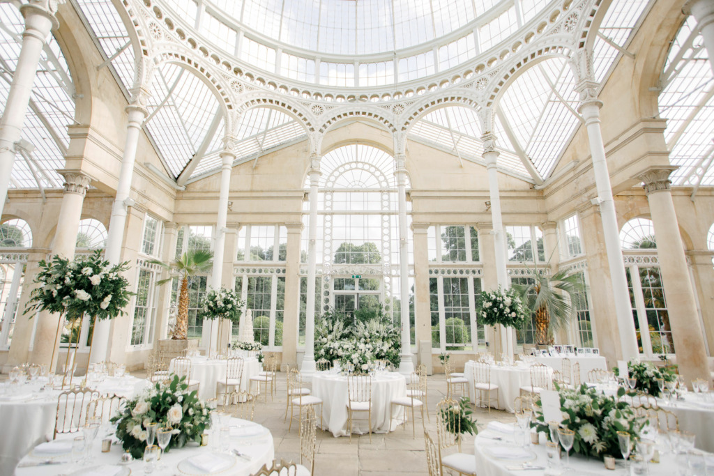Inside the Great Conservatory at Syon Park, under the dome. The room has been set up for a beautiful wedding with green and white floral decorations.